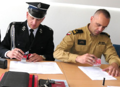 Dwaj mężczyźni w mundurach podczas podpisywania dokumentów 