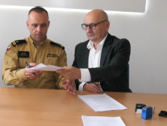 Dwaj panowie przekazują sobie dokumenty