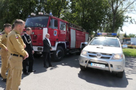 Mężczyźni stoją obok siebie. Oglądają samochód 