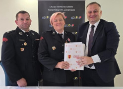 Dwaj mężczyźni i kobieta. Kobieta i mężczyzna trzymają w dłoniach dokument 