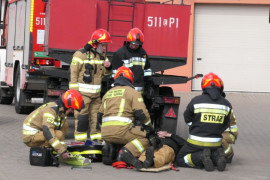 Pokaz strażacki: strażacy udzielają pomocy poszkodowanej osobie 