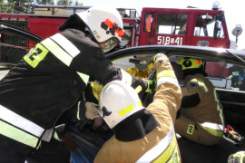 Strażacy wyciągają poszkodowaną osobę z samochodu