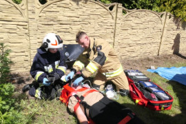 Strażacy udzielają pomocy poszkodowanej osobie