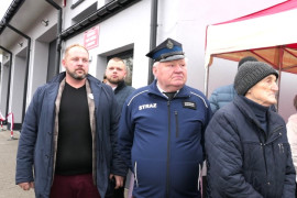 Grupa mężczyzn stojących przed budynkiem OSP Dąbrówka 