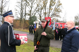 Moment symbolicznego przekazania kluczy do nowego budynku OSP Dąbrówka. Wręczana jest również specjalistyczna piła