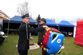 Moment wręczania specjalistycznej torby. Uczestniczą w tym dwaj panowie 