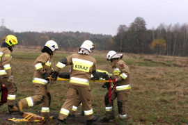 Strażacy podczas pokazów - niosą na noszach poszkodowaną osobę 