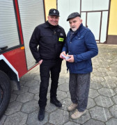 Dwaj mężczyźni. Jeden z nich trzyma w dłoniach czujkę dymu