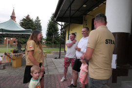 Trzej mężczyźni i kobieta wraz z małym chłopcem stoją obok siebie