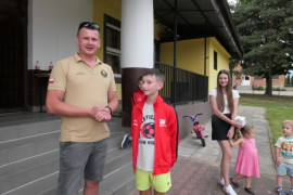 Mężczyzna i dzieci znajdują się przed budynkiem 