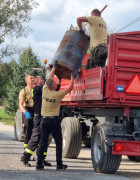 Mężczyźni podczas załadunku zużytego sprzętu na przyczepę 