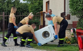 Grupa osób. Osoby odbierają zużyty sprzęt AGD 