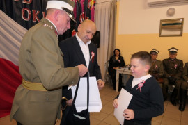 Dwaj mężczyźni wręczają nagrody chłopcu