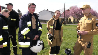 Osoby w strojach staży pożarne stoją obok siebie. Trwa szkolenie 