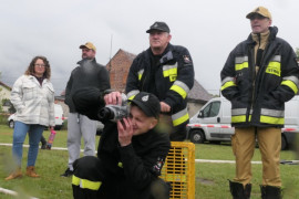 Czterech mężczyzn i kobieta. Jeden z mężczyzn robi zdjęcia aparatem fotograficznym 