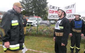 Mężczyzna w stroju strażackim zdaje meldunek 