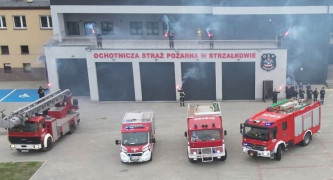 Budynek straży pożarnej oraz wozy bojowe stojące przed strażnicą 