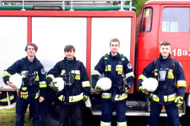 Czterech młodych chłopców w strojach strażaków 