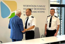 Trzech mężczyzn. Dwóch z nich podaje sobie dłonie