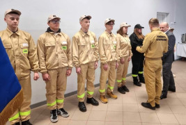Moment wręczania legitymacji członkowskich dla młodych strażaków 