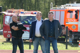 Trzej mężczyźni stoją na murawie boiska 
