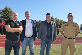 Czterej mężczyźni stoją obok siebie na murawie stadionu