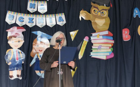 Kobieta stoi przy mikrofonie i przemawia