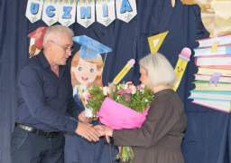 Kobieta i mężczyzna. Mężczyzna wręcza bukiet kwiatów kobiecie 
