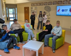 Uczniowie znajdują się w pomieszczeniu. Siedzą na zielonych fotelach 