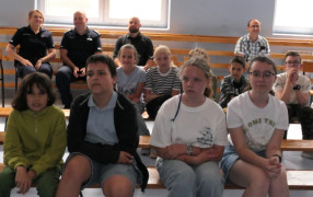 Dzieci siedzą obok siebie na ławce 