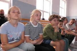 Dzieci siedzą obok siebie na ławce 