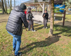 Dorośli i dzieci na świeżym powietrzu. Trwa nagrywanie jednej ze scen filmu edukacyjnego