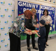 Kobiety wręczają chłopcu nagrodę książkową 