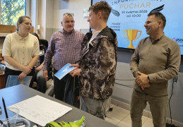 Kobieta, dwóch mężczyzn i chłopiec. Chłopiec odbiera dyplom 