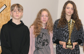 Dwie dziewczyny i chłopak. Dziewczyna trzyma w ręku puchar