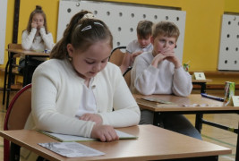 Dziewczynka siedzi w ławce i czyta książkę 