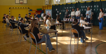 Uczniowie siedzą w ławkach. Uczestnicy konkursu
