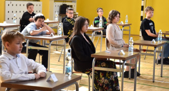 Uczniowie siedzą w ławkach. Uczestnicy konkursu 