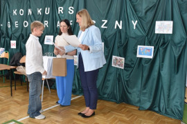 Chłopiec odbiera dyplom z rąk kobiety