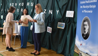 Dziewczynka odbiera dyplom z rąk kobiety