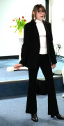 Dziewczyna w czarnych spodniach, czarnej marynarce i białej bluzce podczas recytacji utworu 