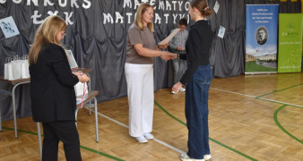 Dwie kobiety i dziewczyna. Jedna z kobiet wręcza uczennicy dyplom 