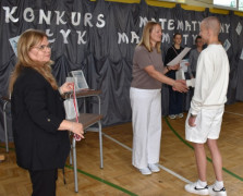 Dwie kobiety i chłopiec. Jedna z kobiet wręcza dyplom chłopcu 
