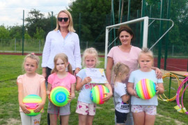 Dzieci i dorośli. Dzieci trzymają w ręku kolorowe piłki 