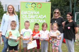 Dzieci i dorośli stoją obok siebie 
