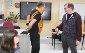 Uczeń podczas zakładania kombinezonu geriatrycznego 