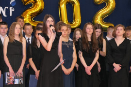 Grupa młodych osób - uczniów klasy ósmej - podczas uroczystej akademii