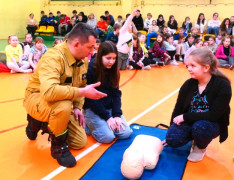 Strażak ochotnik wyjaśnia dzieciom zasady udzielania pierwszej pomocy 