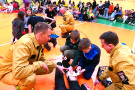 Strażacy podczas wyjaśniania uczniom zasad udzielania pierwszej pomocy 