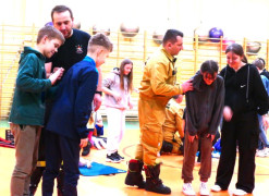 Strażacy tłumaczą uczniom jak pomóc osobie, która zaksztusiła się niebezpiecznym przedmiotem 